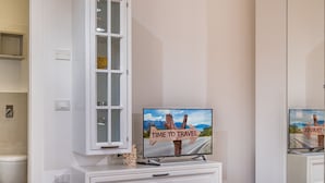 A modern bathroom with a toilet, a cabinet with a television, and a tray with pastries and a coffee pot. - Casa del Golfo Cascio 3 Secondo Piano (Castellammare del Golfo)