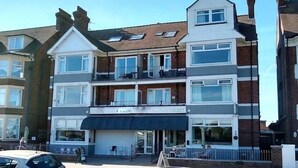 A multi-story building with a ground-floor restaurant and upper residential units. - Harbour Stays (Skegness)