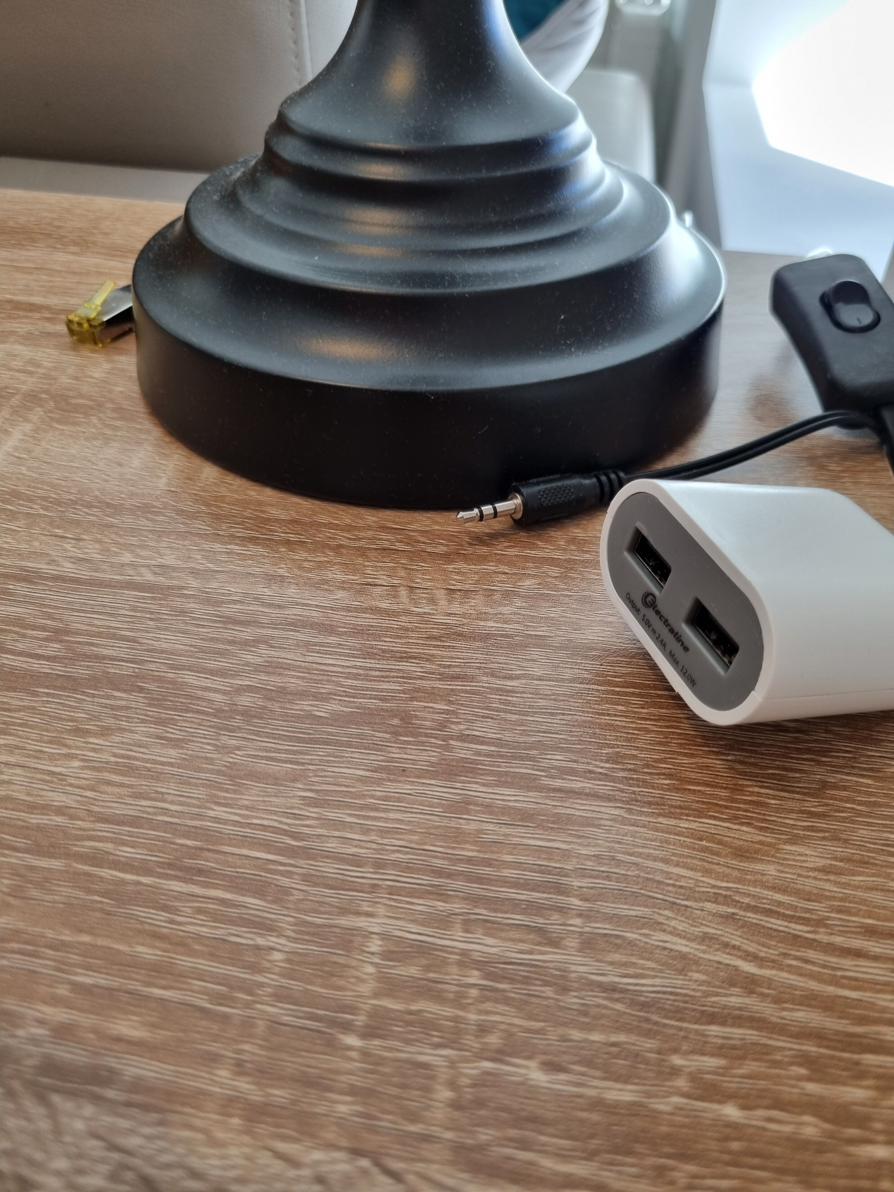 A desk lamp with a USB charging cable plugged in.