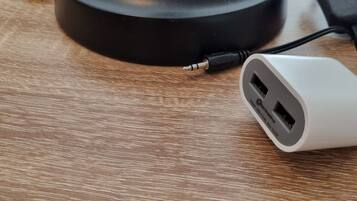 A desk lamp with a USB charging cable plugged in.