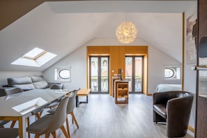 Un dormitorio estilo loft moderno con tragaluces, una zona de comedor y un balcón.