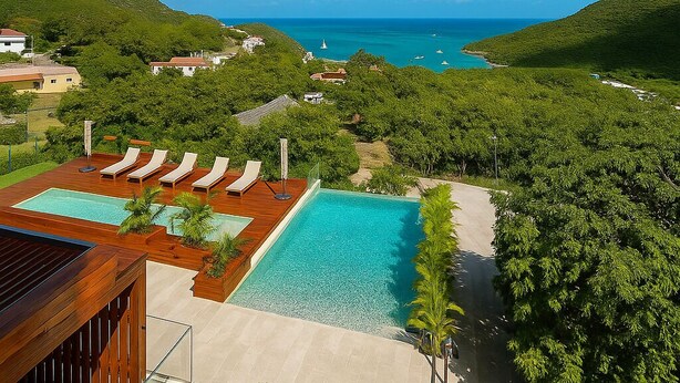Un resort con una piscina grande, sillas de descanso y vistas al océano.
