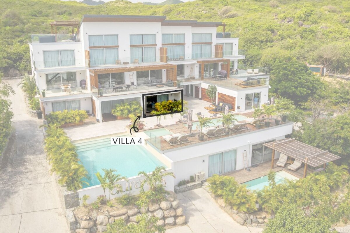 A modern villa with multiple levels, a swimming pool, and lush greenery surrounding the property.