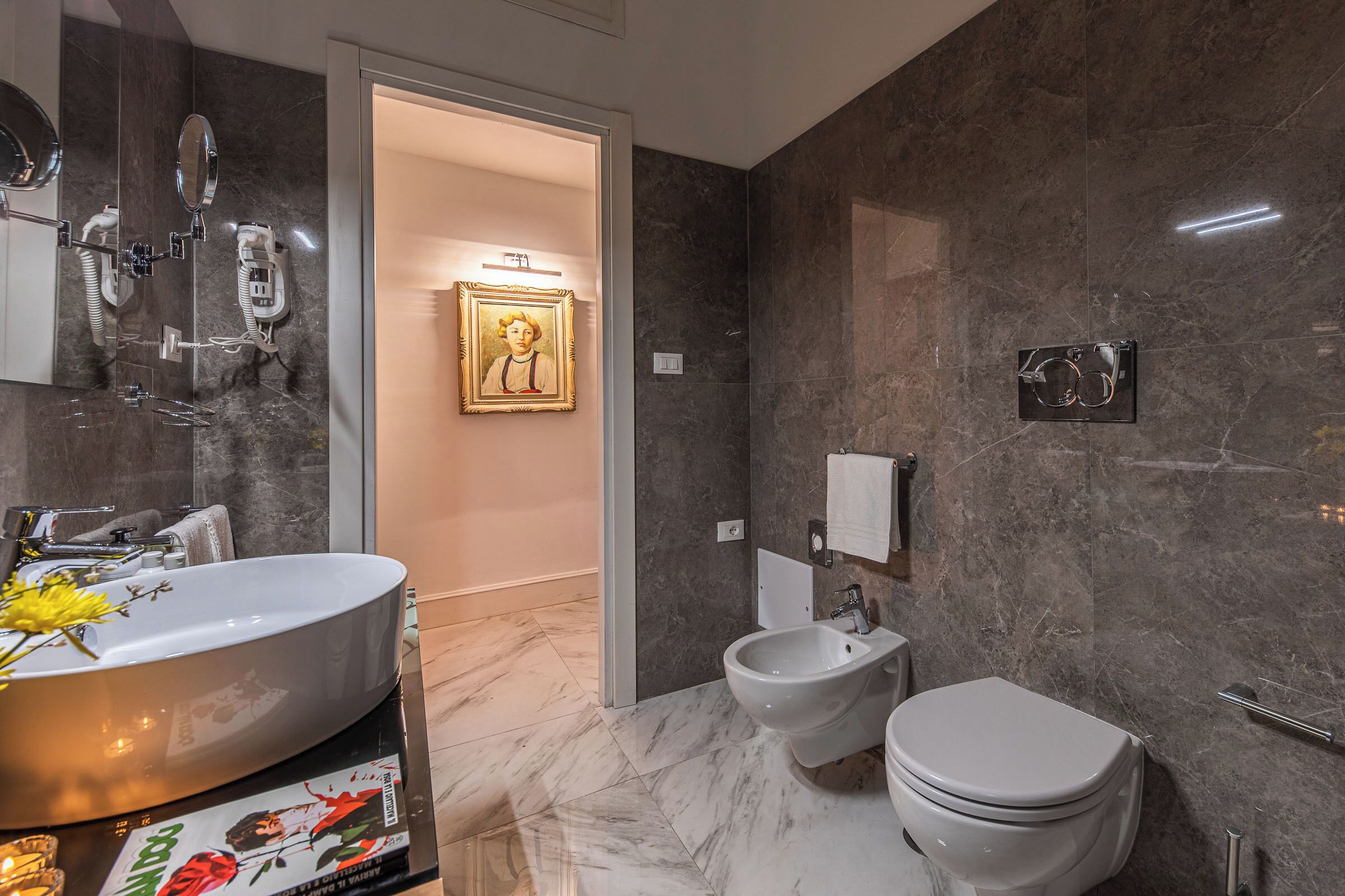 A modern bathroom with a large sink, bidet, and toilet.