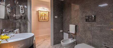 A modern bathroom with a large sink, bidet, and toilet.