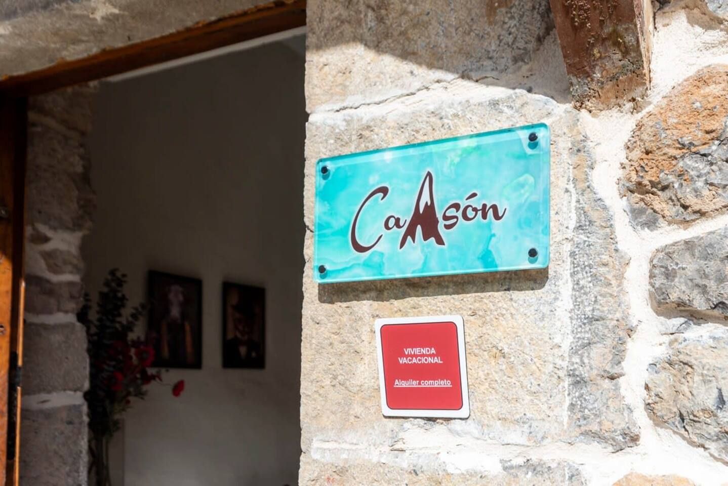 A sign with the name 'Caason' on a stone wall, indicating a vacation rental property.