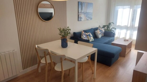 A modern living room with a dining table, chairs, a sofa, and a coffee table. - Sailor home Santander (Santander)