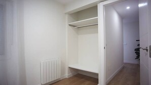 A room with a white radiator, a wooden floor, and a white door with a handle. - Sailor home Santander (Santander)