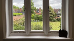 A window with three panes overlooking a garden and residential area. - 1bedapt Privateestate W/free Parking - 10mintocity (Nottingham)