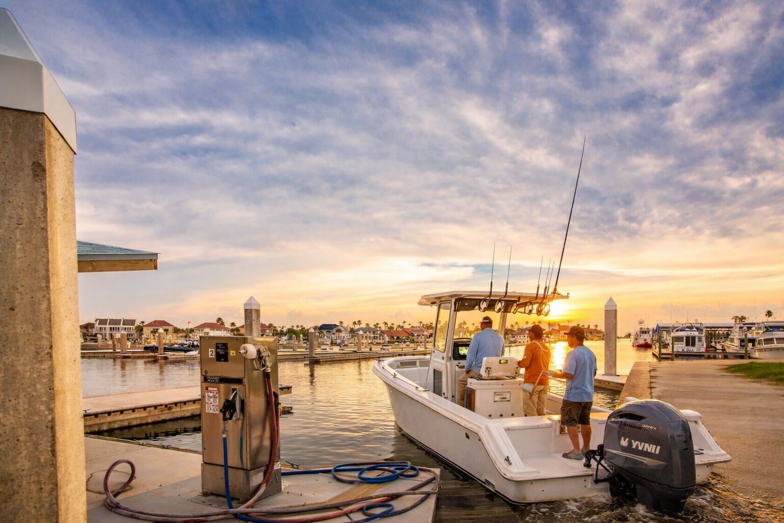 A marina with boats docked, a jetty, and a clear sky.