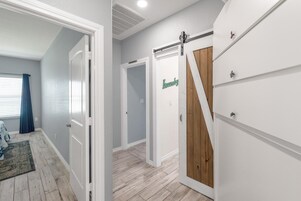 A hallway with a wooden floor, white walls, and a door labeled "Laundry".