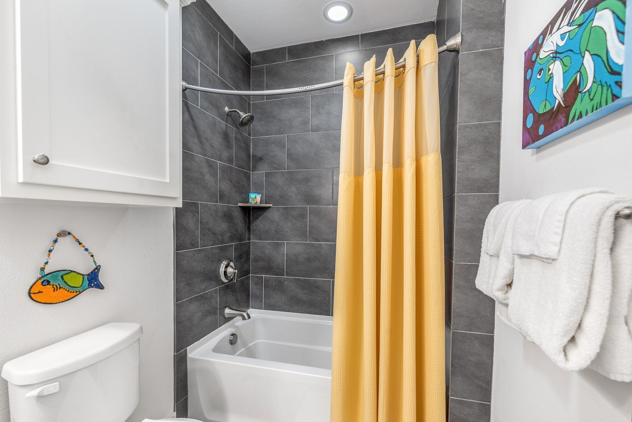 Une salle de bain avec une baignoire, des toilettes et un rideau de douche.