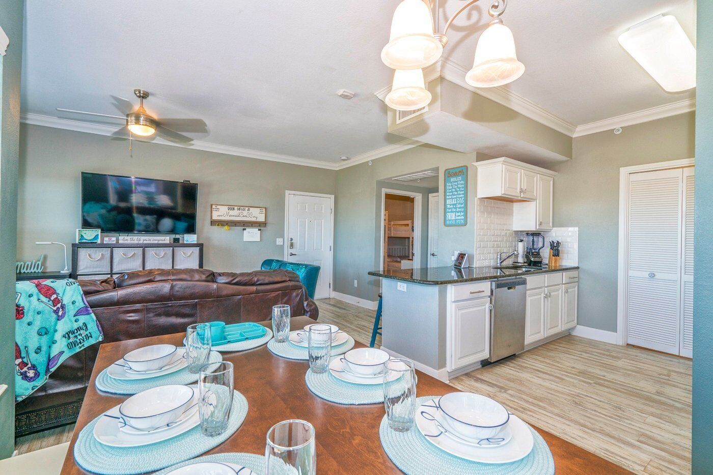 A modern kitchen with white cabinets, a built-in oven, and a stainless steel sink.