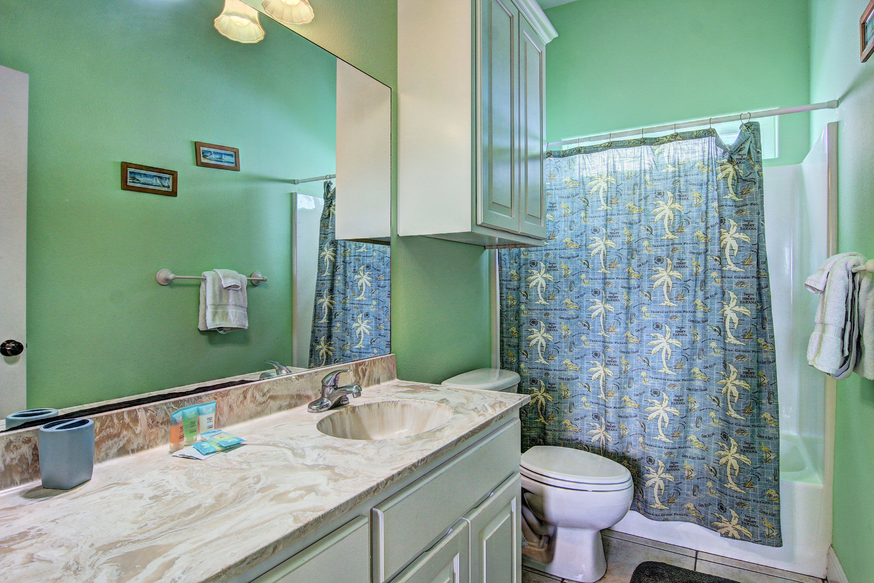 A bathroom with a sink, mirror, and toilet.