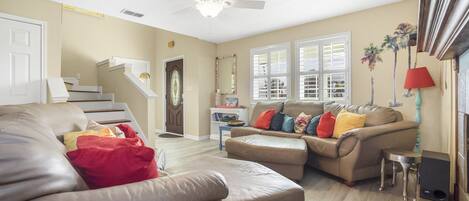A living room with a beige sofa, a coffee table, and a red lamp.