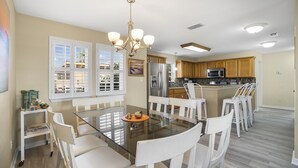 A spacious kitchen with a central island, white cabinetry, and a modern chandelier. - Palma Verde - Pet Friendly! (Port Aransas)
