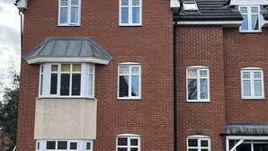 A multi-story brick building with white-framed windows and a bay window on the ground floor. - Sleeps 4 With Ensuite and Free Parking (Lincoln)