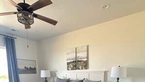 A bedroom with a bed, bedside tables, a ceiling fan, a window with curtains, and artwork on the wall. - The Lyman House (Lyman)