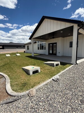 A modern building with a covered porch, a gravel driveway, and a well-maintained lawn.
