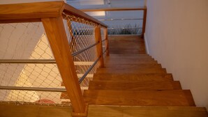 A wooden staircase with metal railings and a chain-link barrier. - Casa 5 Estrelas Top!!! All Incluse com 3 Funcionários (Praia de Maresias São Sebastião)