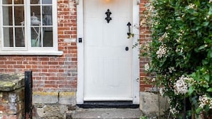 A white door with a black knocker, a small porch, and a brick wall. - 'Darling Buds of May' Glorious 17th Century Idyll (Heddington)