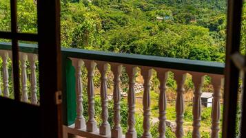 A balcony with a view of a lush green landscape and mountains.