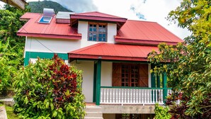 A two-story house with a red roof, white walls, and green accents. - Roxy's Mountain Lodge (Laudat)