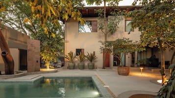 Een buitenzwembad, parasols bij het zwembad en ligstoelen