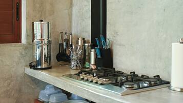 Una cocina con estufa a gas, electrodomésticos de acero inoxidable y diversos utensilios.