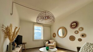 Ein Wohnzimmer mit einer Couch, einem Couchtisch, einem Fernseher und einem Fenster mit Blick.