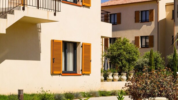 A two-story building with a sign reading "Résidence Calme." - Appartement 2 Chambres (Saint-Florent)