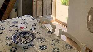 A room with a table set for dining, a wooden ladder, and a door leading outside.