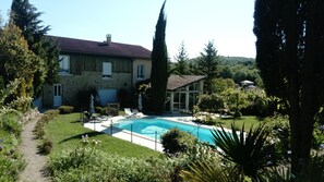 Enjoy a tranquil retreat in our backyard with a swimming pool surrounded by lush greenery and mature trees.