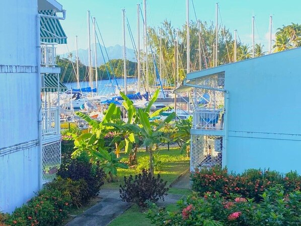 A marina with boats docked, surrounded by lush greenery and a clear sky. - Key Caraïbe - T3 au Coeur de la Pointe du Bout - Plage 150m - (Les Trois-Îlets)