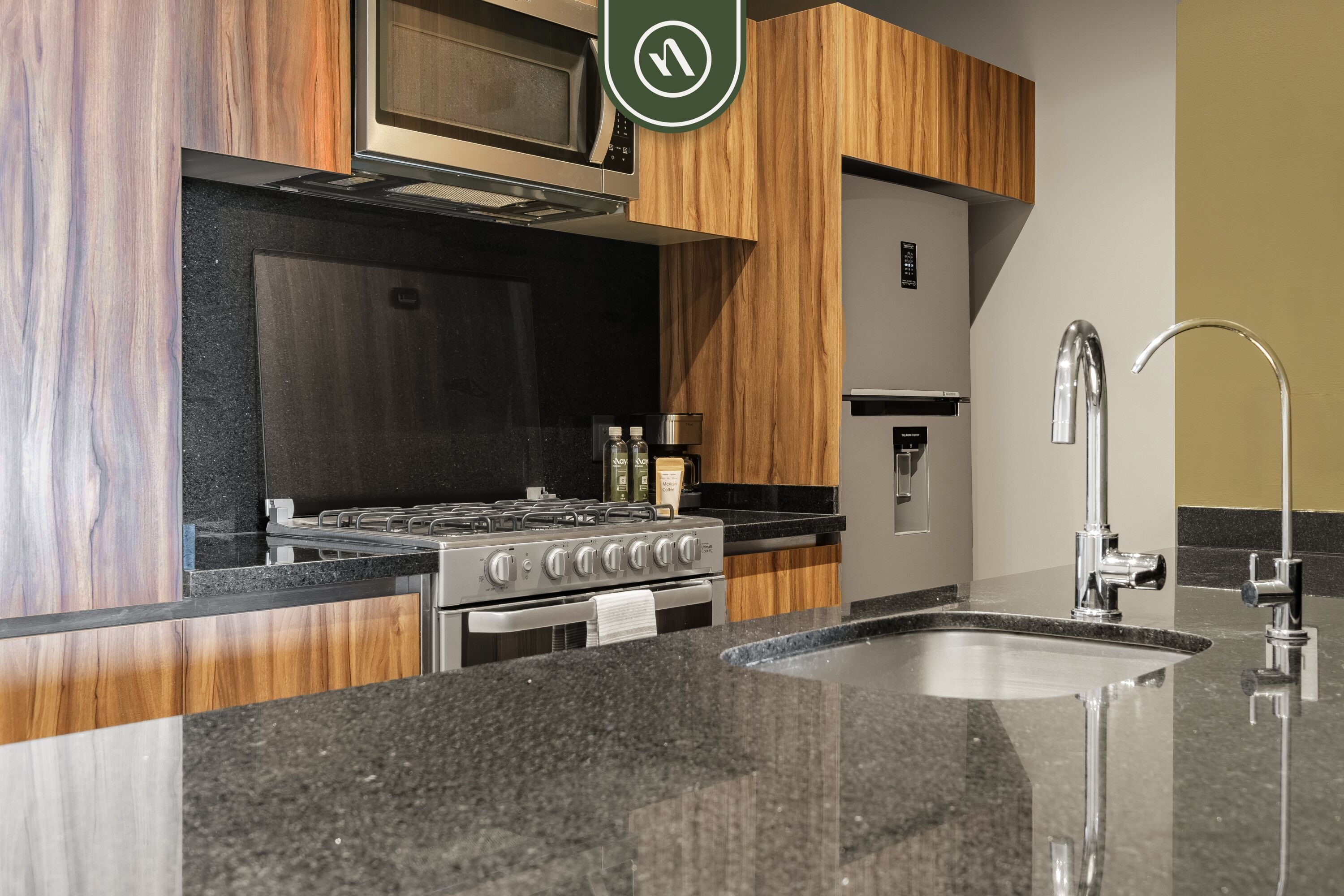 A modern kitchen with a stainless steel stove, wooden cabinets, a built-in microwave, and a sink with a modern faucet.