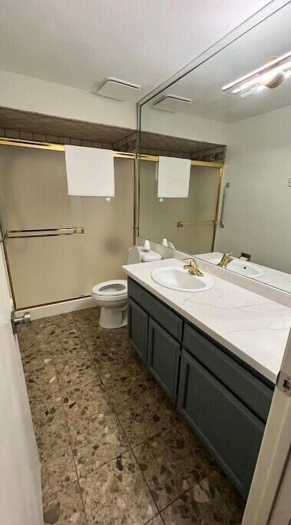 A bathroom with a white sink, a mirror, and a toilet. - Desert lake condo (Phoenix)