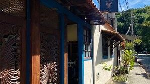 Un edificio tradicional con puertas de madera ornamentadas, una antena parabólica y un cartel que indica un parque cercano.
