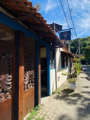 Un edificio tradicional con puertas de madera ornamentadas, una antena parabólica y un cartel que indica un parque cercano.