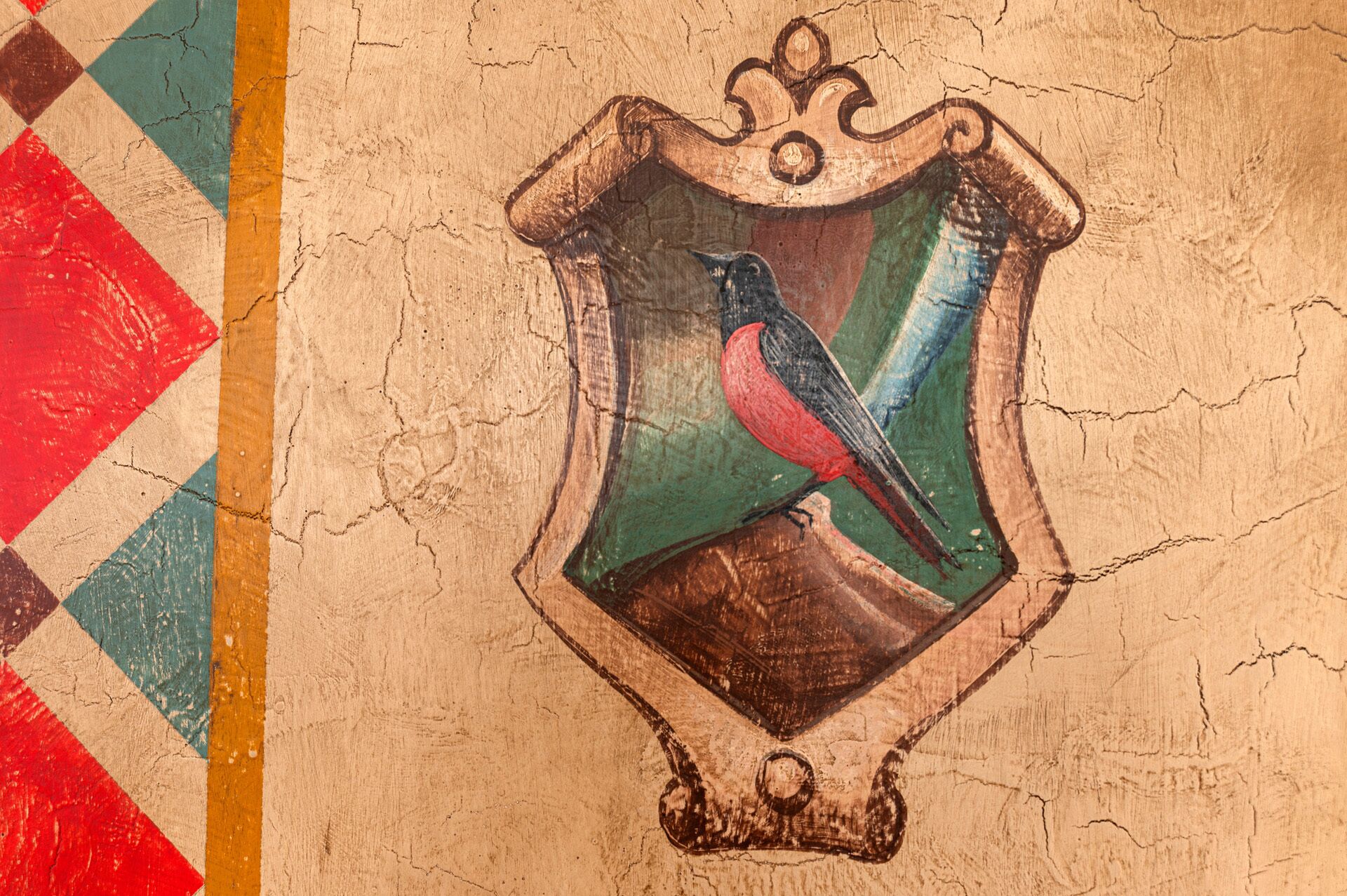 Uno stemma a forma di scudo con un uccello, forse un corvo, su un muro strutturato.