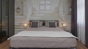 Una camera da letto con un letto grande, due abat-jour e vista su una maestosa scalinata.