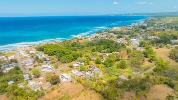 Vista aérea de un pueblo costero con casas, calles y una playa.