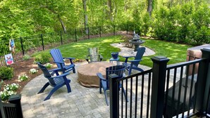A patio area with a fire pit, outdoor seating, and a well-maintained lawn. - Custom 4-bedroom home, boat slip, fenced backyard, pool & paved bike path. (Cape Charles)
