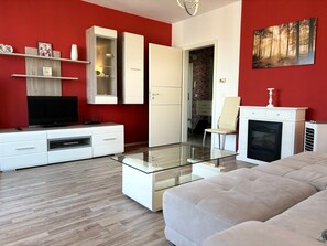 Smart-tv, eldstad och ett bordtennisbord