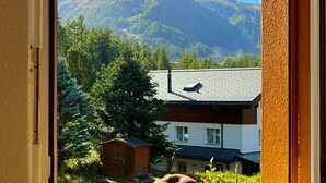A window with a view of a mountain and a house. - Haus Vira (Zermatt)