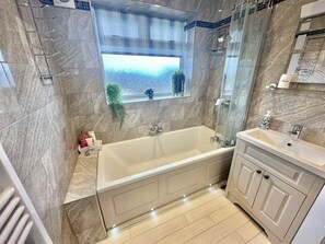 Enjoy a relaxing soak in the spacious bathtub with a clear view of the shower area.