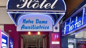 A hotel entrance with a neon sign reading "Hotel Notre Dame Auxiliatrice" and a visible room number "28". - N.D. Auxiliatrice (Lourdes)
