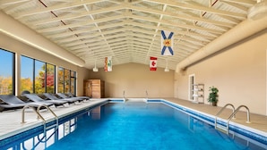 An indoor swimming pool with a high ceiling, clear windows, and flags. - Park Inn - by Choice Hotels, Sydney (Sydney)