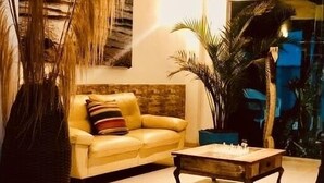 Un salon avec un canapé, une table basse et un grand vase.