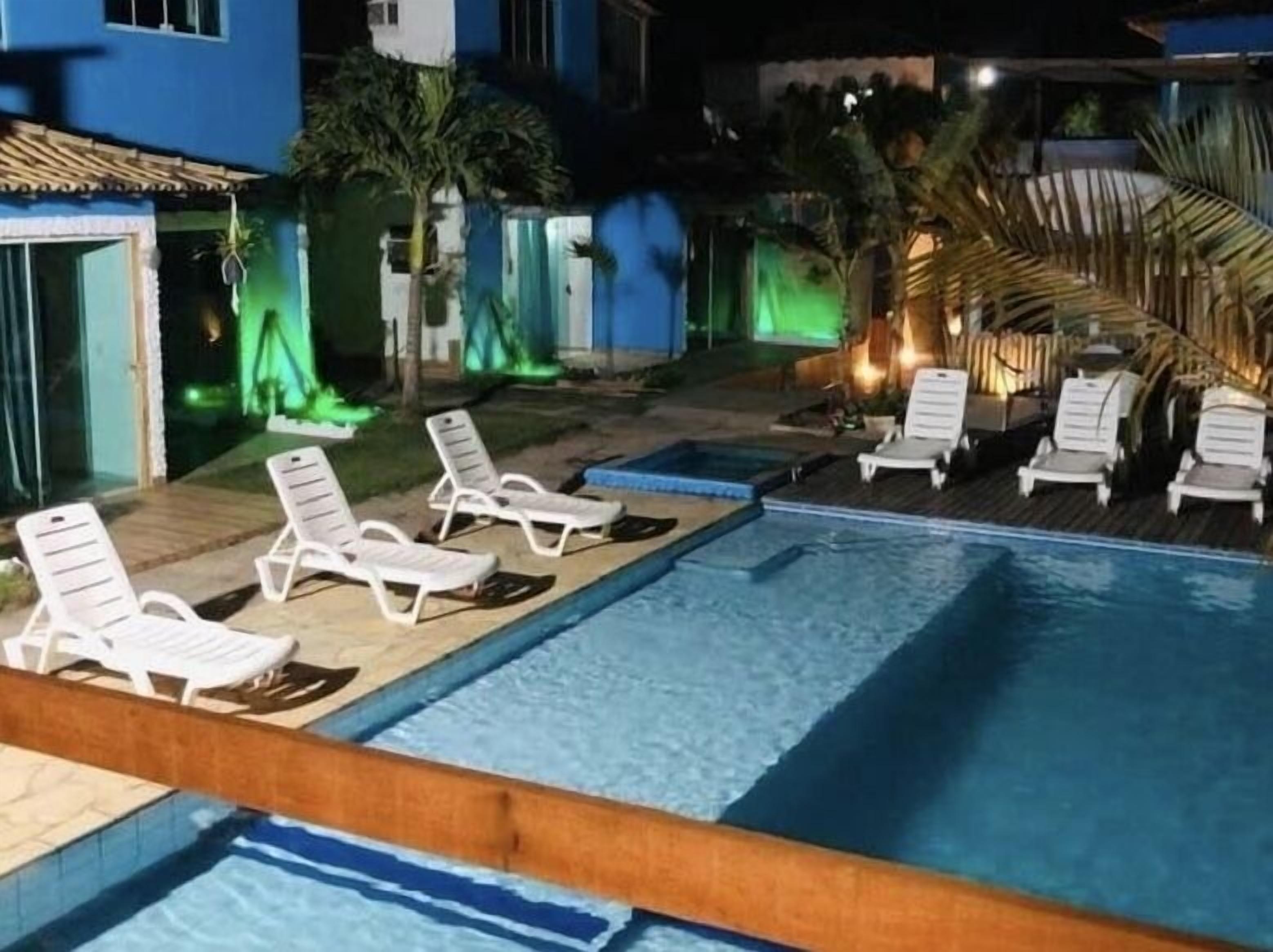 A swimming pool with lounge chairs and a wooden deck.