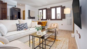 Una sala de estar moderna con un sofá, una mesa de centro y una televisión.